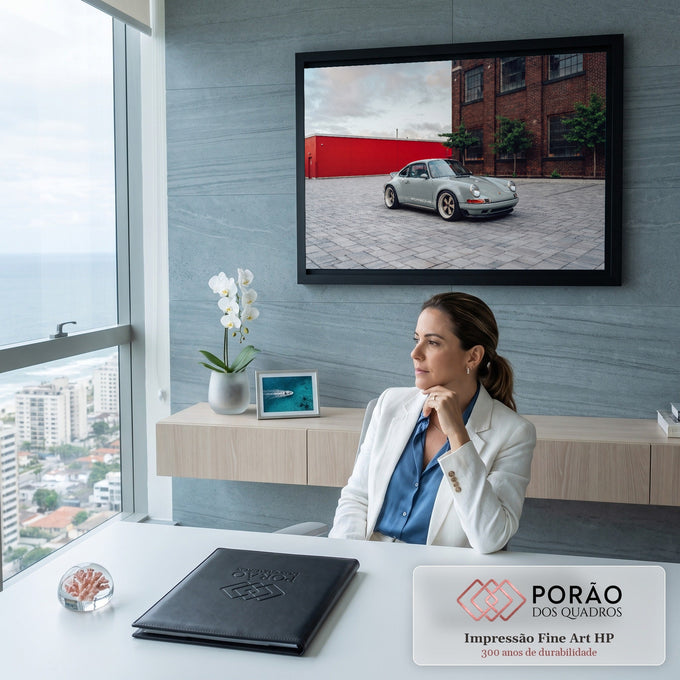 Porsche 911 clássico cinza com rodas douradas em pátio de pedras e prédio de tijolos, quadro decorativo