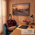 Barco de madeira rústico na areia entre capim de dunas com pôr do sol laranja no mar, quadro decorativo