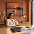 Quadro Decorativo Grande Veleiro e Farol Laranja para Sala | quadros decorativos | veleiro navegando ao pôr do sol com farol aceso sobre penhasco rochoso | em ambiente 2 | Porao dos Quadros