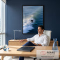 Surfista de roupa preta em prancha azul sobre onda do mar com espuma branca e movimento, quadro decorativo