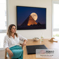 Quadro Decorativo Grande Pirâmide de Gizé para Sala Laranja | quadros decorativos | pirâmide egípcia iluminada em laranja com lua cheia atrás do topo contra céu azul escuro | em ambiente 2 | Porao dos Quadros