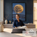 Lua cheia dourada gigante atrás de árvore sem folhas em colina com neve e céu azul, quadro decorativo