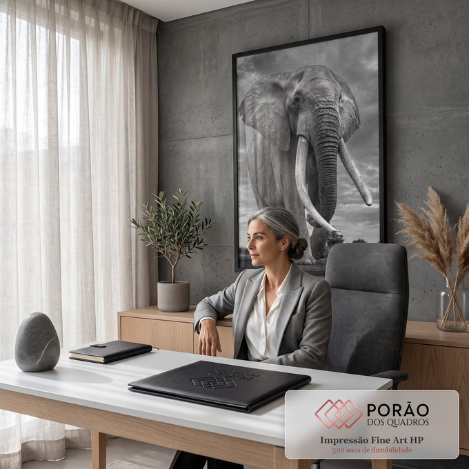 Elefante africano de presas longas caminhando sob céu nublado em preto e branco, quadro decorativo