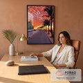 Pôr do sol laranja e vermelho sobre orla com palmeiras, ciclistas e mar ao fundo, quadro decorativo