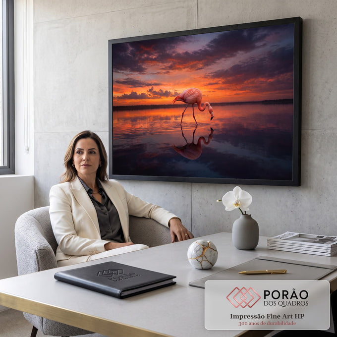 Flamingo rosa caminhando em lago calmo com reflexo na água sob céu laranja de pôr do sol, quadro decorativo