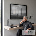 Homem idoso diante de portal metálico na praia sob céu nublado, em preto e branco, quadro decorativo