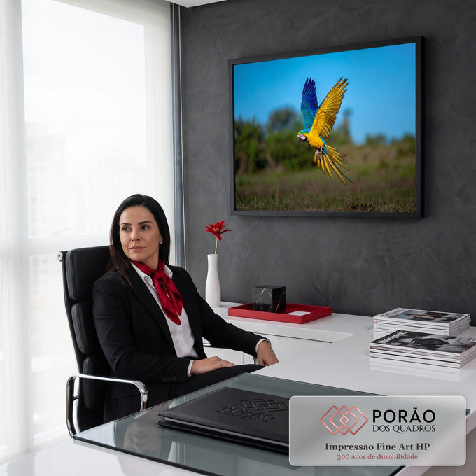 Arara-canindé azul e amarela em voo com asas abertas sobre campo verde e céu azul, quadro decorativo