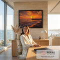 Quadro Decorativo Grande Farol ao Pôr do Sol Mar para Sala | quadros decorativos | farol branco contra céu laranja intenso com barco solitário e praia de pedras | em ambiente 2 | Porao dos Quadros