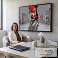 Mulher com maquiagem de pierrô, chapéu vermelho e coração diante de canal de Veneza cinza, quadro decorativo
