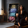 Frase Eat Sleep Game Repeat em letras neon amarelo, azul e vermelho sobre tijolos escuros, quadro decorativo