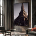 Torre Eiffel vista de baixo, estrutura de ferro escura com luz dourada e céu lilás, quadro decorativo