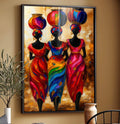 Quadro Decorativo Feminino Cultura Africana | quadros decorativos para sala | Três mulheres africanas em silhueta com vestes e lanternas vermelhas, azuis e laranja vibrantes. | Porao dos Quadros