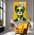 Quadro Decorativo - Frida Kahlo em Cores Vibrantes | quadros decorativos para sala | Mulher com óculos redondos amarelos, flores coloridas na cabeça, fundo amarelo vibrante, estilo Pop Art. | Porao dos Quadros