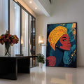 Quadro Decorativo Empoderamento Feminino em Cores Vibrantes | quadros decorativos para sala | Mulher africana com turbante laranja, rosto vermelho, folhas azuis e douradas ao fundo. | Porao dos Quadros