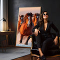 Cavalos marrons galopando com crina ao vento e céu rosado ao fundo, quadro decorativo