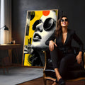 Retrato de mulher com óculos redondos em pontilhado preto e branco sobre fundo amarelo, quadro decorativo