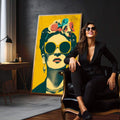 Quadro Decorativo - Frida Kahlo em Cores Vibrantes | quadros decorativos para sala | Mulher com óculos redondos amarelos, flores coloridas na cabeça, fundo amarelo vibrante, estilo Pop Art. | em Quadros para Sala | Porao dos Quadros