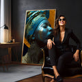 Mulher negra de perfil com turbante azul, pintura dourada no rosto e brinco grande, quadro decorativo