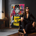 Quadro Decorativo Love é a Resposta | quadros decorativos para sala | Mulher em preto e branco com cartaz amarelo 'Love is Answer' em fundo pop art colorido com magenta, azul e padrões abstratos. | em Quadros para Sala | Porao dos Quadros