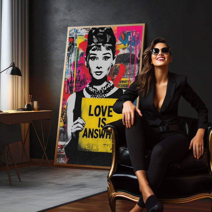 Quadro Decorativo Love é a Resposta | quadros decorativos para sala | Mulher em preto e branco com cartaz amarelo 'Love is Answer' em fundo pop art colorido com magenta, azul e padrões abstratos. | em Quadros para Sala | Porao dos Quadros