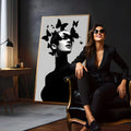 Mulher de gola alta preta com borboletas pretas cobrindo os olhos em fundo cinza claro, quadro decorativo