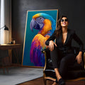 Arara de perfil com penas azuis, amarelas, laranja e roxas sobre fundo azul-petróleo, quadro decorativo