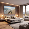 Quadro Decorativo Jesus Harmonia à Beira do Mar | quadros decorativos premium | Surfista caminhando na praia ao entardecer com sombra alongada e ondas ao fundo | em ambiente 4 | Porao dos Quadros