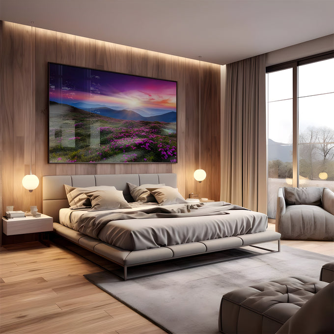 Montanhas ao pôr do sol com céu roxo e campo de flores magenta em primeiro plano, quadro decorativo