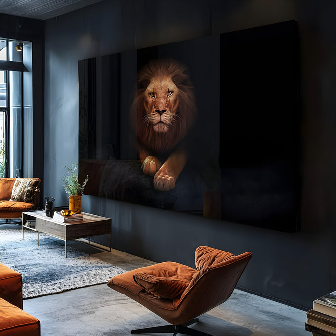 Leão de juba acobreada deitado com patas cruzadas e olhar frontal sobre fundo preto, quadro decorativo