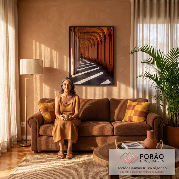 Corredor de arcos terracota com faixas de luz e sombra e pessoa caminhando ao fundo, quadro decorativo