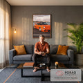 Quadro Decorativo Carro Clássico Laranja Pôr do Sol no Mar | quadros decorativos para sala de estar | carro esportivo laranja com aerofólio à beira da água e skyline ao fundo | em ambiente 3 | Porao dos Quadros