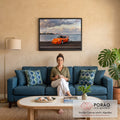 Porsche 911 laranja com aerofólio na orla, mar e skyline sob nuvens ao entardecer, quadro decorativo