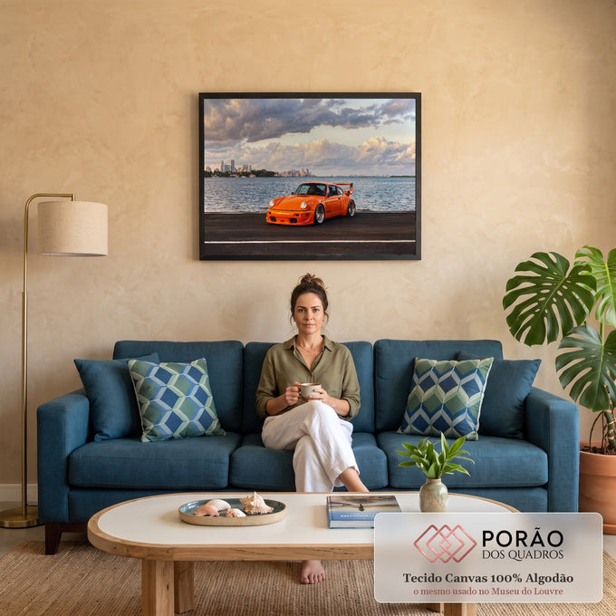 Porsche 911 laranja com aerofólio na orla, mar e skyline sob nuvens ao entardecer, quadro decorativo