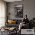 Narciso amarelo solitário entre rochas vulcânicas pretas sob céu nublado, cor seletiva, quadro decorativo