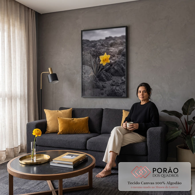 Narciso amarelo solitário entre rochas vulcânicas pretas sob céu nublado, cor seletiva, quadro decorativo