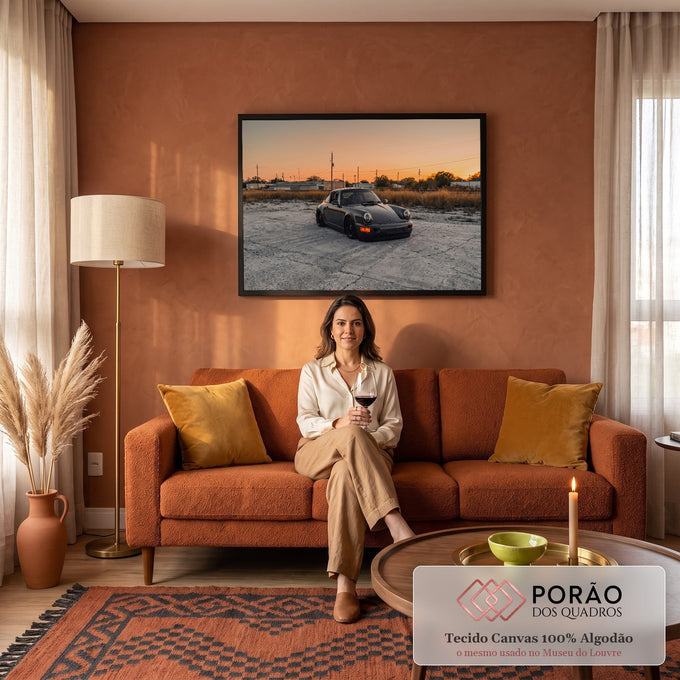 Porsche 911 preto rebaixado sobre concreto com céu alaranjado de pôr do sol, quadro decorativo