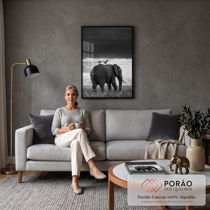 Elefante com duas garças no dorso sob céu escuro e raios de luz em preto e branco, quadro decorativo