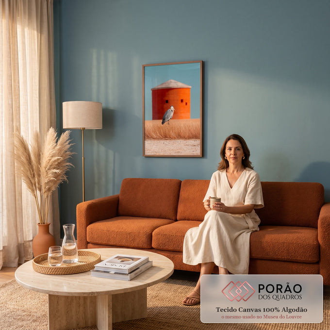 Garça-cinzenta em campo de grama dourada com silo laranja e céu azul ao fundo, quadro decorativo