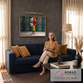 Mulher de casaco amarelo em balanço diante de rosto gigante com galhos secos, fundo verde, quadro decorativo