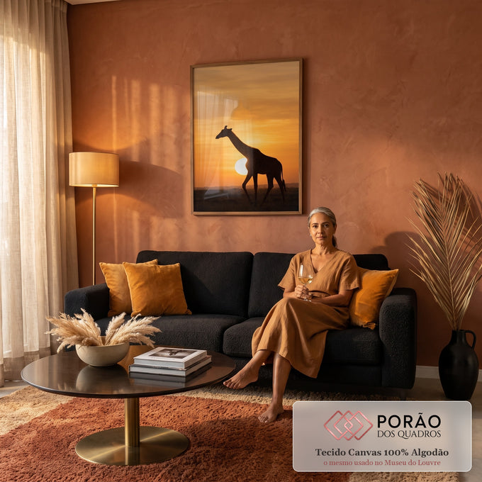 Silhueta de girafa caminhando na savana com sol baixo e céu laranja ao entardecer, quadro decorativo