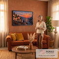 Dois gatos num muro de pedra olhando o pôr do sol laranja sobre o mar, penhascos e vilarejo, quadro decorativo