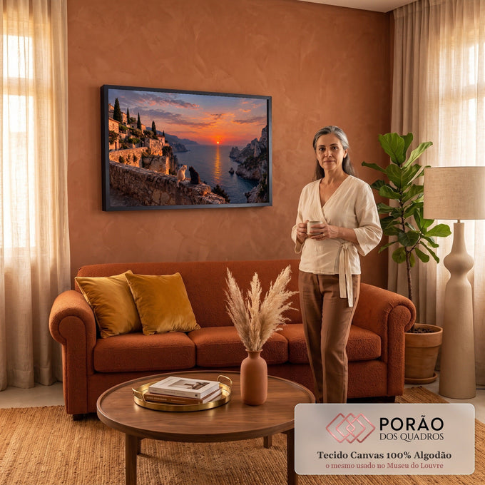 Dois gatos num muro de pedra olhando o pôr do sol laranja sobre o mar, penhascos e vilarejo, quadro decorativo