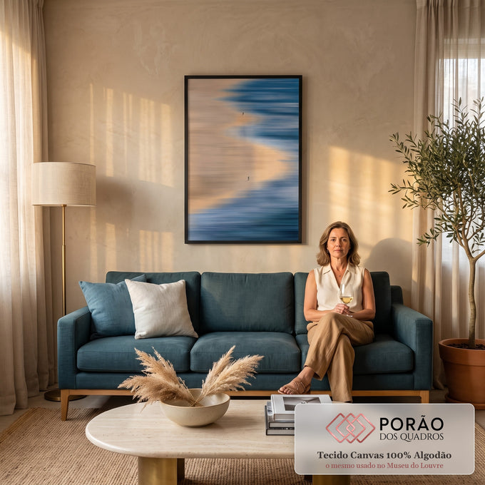 Praia vista do alto com mar azul em movimento, areia bege e duas pessoas caminhando, quadro decorativo