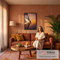 Mulher sentada na proa de veleiro sobre o mar ao pôr do sol em tons laranja, quadro decorativo