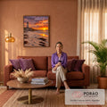 Farol branco sobre rochas, praia com pegadas e algas e pôr do sol laranja no mar, quadro decorativo