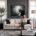 Fotografia em preto e branco de espuma do mar na areia escura com sol refletindo, quadro decorativo