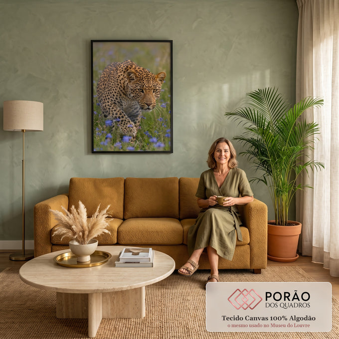 Leopardo agachado à espreita, olhar intenso, em campo verde com flores lilás, quadro decorativo