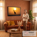 Silhueta de girafa sob sol gigante e céu laranja, com montanhas da savana africana ao fundo, quadro decorativo