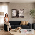Elefante africano de presas longas caminhando sob céu dramático em fotografia sépia, quadro decorativo