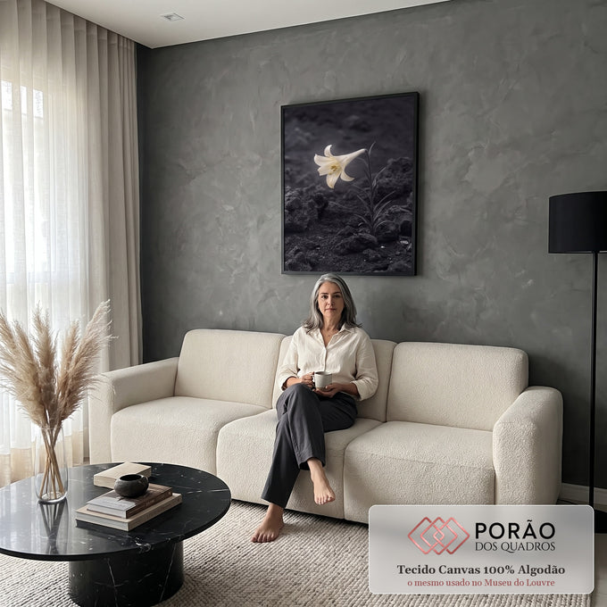 Lírio branco solitário iluminado sobre solo de pedras vulcânicas escuras, quadro decorativo